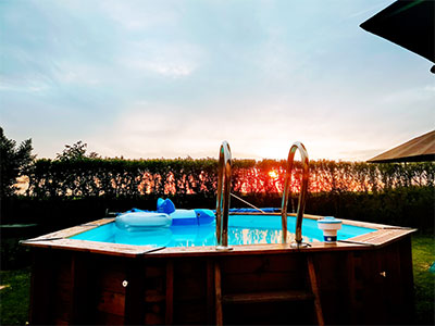A portable above ground pool with a ladder. This one has a wooden outside finish.