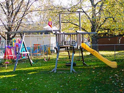 A big swing set that includes a slide, swings and a "tower"
