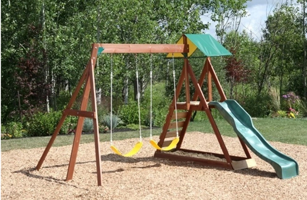 A smal playset with  two swings, a rock wall and ladder combo, a slide and a bottomless sandpit.